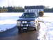 1998 Chevrolet Tahoe - A black SUV with a bull bar and auxiliary lights is parked in front of a shed on a snowy day.