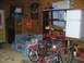 1988 Ford Bronco - Interior view of a garage containing various items including tires, a bed, shelving, and bicycles.