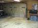 1988 Ford Bronco - The interior of a garage is shown, a large overhead door and various items stored within.