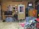 1988 Ford Bronco - A cluttered garage scene with various items including tools, storage, and a covered object.