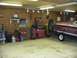 1988 Ford Bronco - A boat on a trailer is parked inside a garage, surrounded by various tools and equipment.