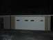 1988 Ford Bronco - Exterior view of a garage with a white double door at night.