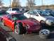 1979 Ford Bronco - A red sports car sits with significant front-end damage, its wheel detached and lying nearby.