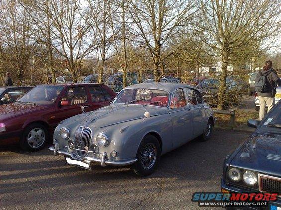 Gray Jaguar Mark II parked next to a red car and a dark blue car