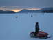 1995 Ford Bronco - Multiple snowmobiles are visible on a vast, snow-covered expanse under a cloudy sky at dusk.