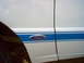 1993 Ford Ranger - A close-up of a white truck's side panel shows blue racing stripes and a Ford emblem.