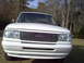 1993 Ford Ranger - Frontal view of a white 1993 Ford Ranger pickup truck parked outdoors with trees in the background.