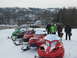 1995 Ford Bronco - A group of people pose behind a line of snowmobiles on a snowy day with a town in the background.