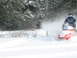 1995 Ford Bronco - Snowmobile rider kicks up a cloud of snow while riding through a wooded area.