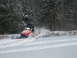 1995 Ford Bronco - A snowmobile kicks up snow as it travels across a winter landscape.