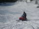 1995 Ford Bronco - A rider navigates a snowmobile down a groomed slope, leaving tracks in the snow.