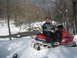1995 Ford Bronco - A man poses on a red Polaris snowmobile in a winter landscape with trees and a stream.