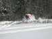 1995 Ford Bronco - A snowmobile navigates a snowy trail through a wooded area.
