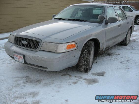 Silver Ford Crown Victoria with a honeycomb grille and a license plate reading FUGATE