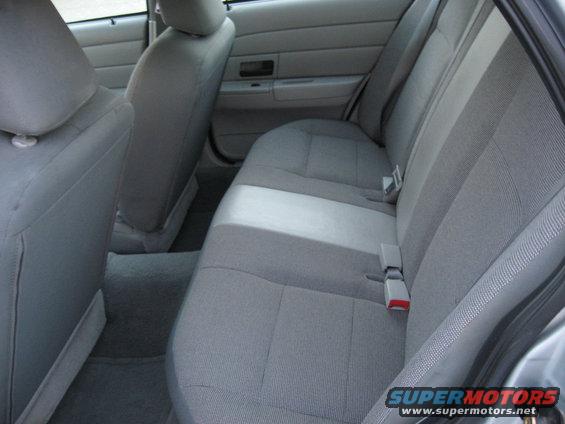 Back seat and interior of a car, showing gray fabric seats and door panel