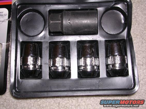 Set of four chrome lug nuts and a black lug nut key in a plastic package