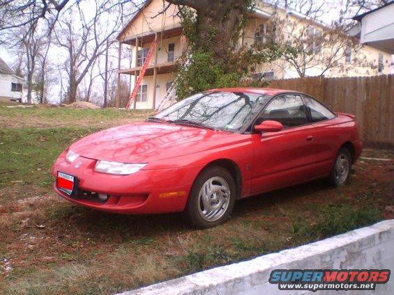 Red 1997 Saturn SC coupe parked in a yard