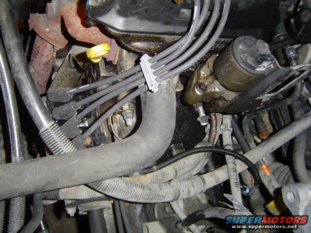 Engine bay detail showing spark plug wires, hoses, and engine mounts