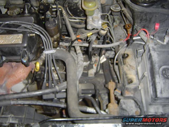 engine bay with wires, hoses, and engine components visible. Some parts look worn