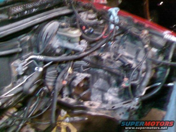 engine bay with brake fluid reservoir and various hoses and wires