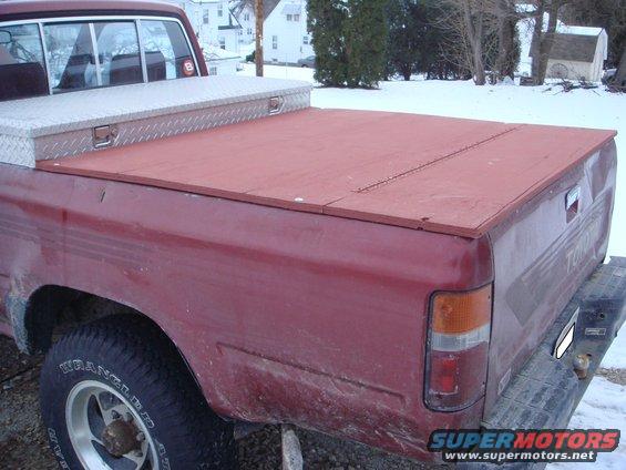 Red truck bed cover and diamond plate toolbox on a red pickup truck