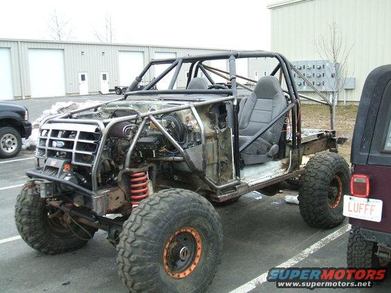 1995 Ford Bronco modified with a roll cage, exposed engine, and large off-road tires