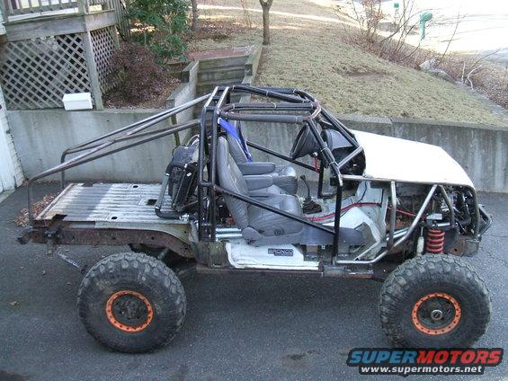 Modified off-road vehicle with roll cage, exposed frame, and large tires