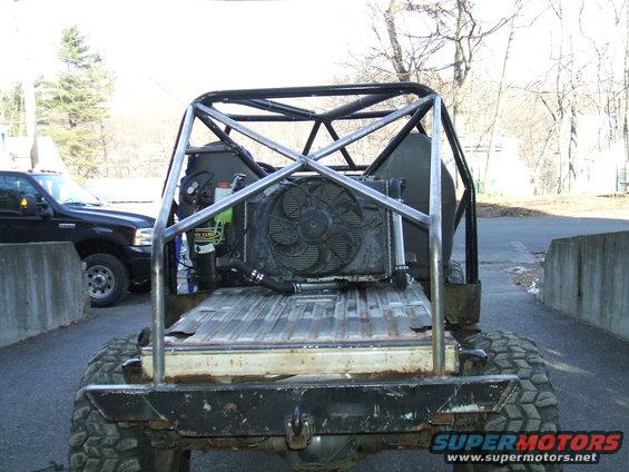 Rear view of custom off-road vehicle with roll cage, large fan, and aftermarket bumper