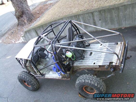 Custom buggy with roll cage, off-road tires, and exposed frame. Looks like it's been stripped down and modified