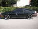1989 Ford Probe - Side profile of a black 1989 Ford Probe coupe with custom wheels and tinted windows.