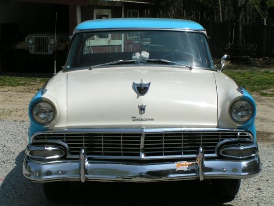 1956 Ford Fairlane front view with blue roof and chrome grille. Another vehicle is visible in the background