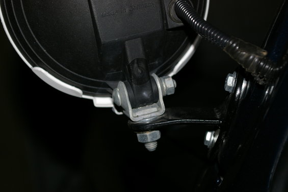 Close-up of a headlight bracket with bolts and wiring
