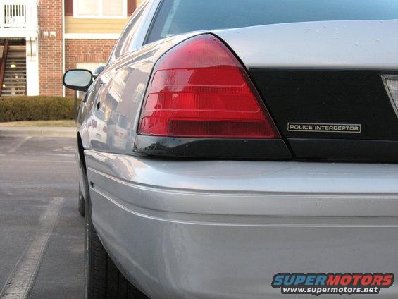 Silver 2004 Ford Crown Victoria Police Interceptor rear quarter panel with taillight and 'POLICE INTERCEPTOR' badge