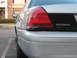 2004 Ford Crown Victoria - Rear view of a silver 2004 Ford Crown Victoria Police Interceptor, showing the taillight and badge.