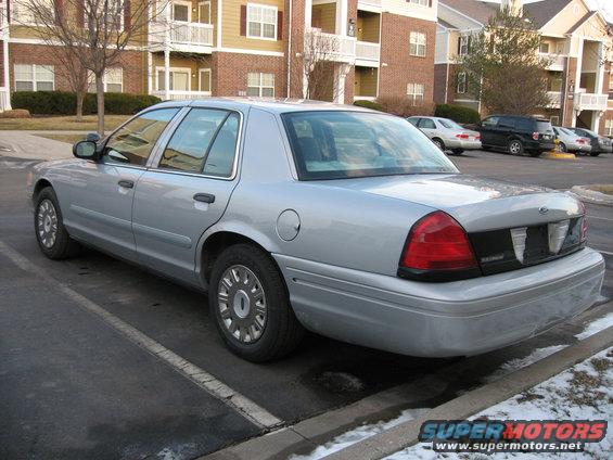 Silver 2004 Ford Crown Victoria parked in a lot with apartment buildings in the background