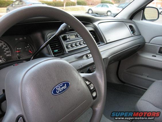 Gray 2004 Ford Crown Victoria interior showing steering wheel with Ford logo, dashboard, and radio