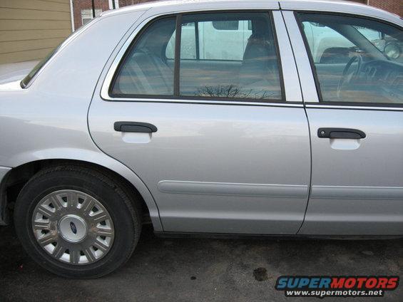 Silver 2004 Ford Crown Victoria side view showing rear door and wheel