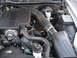 2004 Ford Crown Victoria - Engine bay of a 2004 Ford Crown Victoria, showing the alternator, air intake, and various hoses.