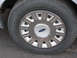 2004 Ford Crown Victoria - This image shows a close-up of a Ford wheel, a silver hubcap with the iconic blue Ford logo in the center.