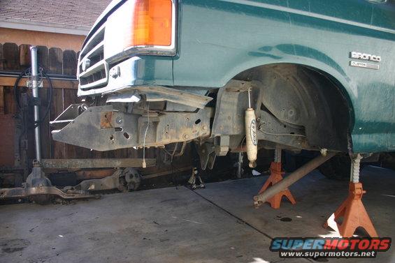 Green 1991 Ford Bronco front end on jack stands, showing suspension and frame
