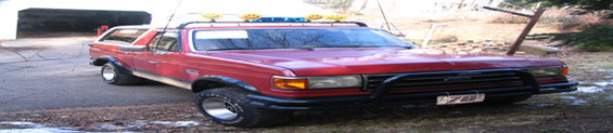 Red 1989 Ford Bronco with a roof rack and brush guard