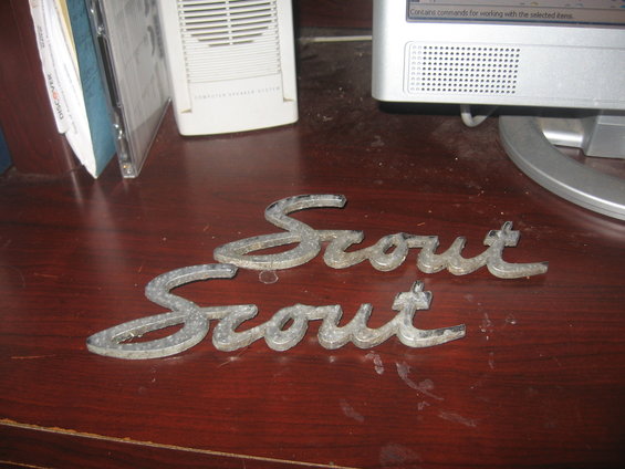 Two metal Scout emblems on a wooden surface