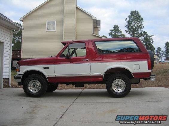 Red and white 1995 Ford Bronco parked on a driveway