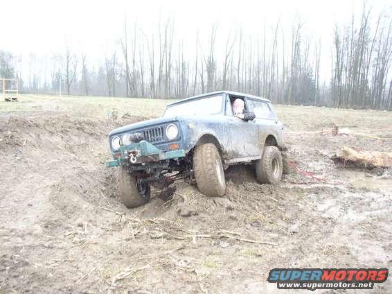 Blue off-road vehicle with winch on muddy terrain