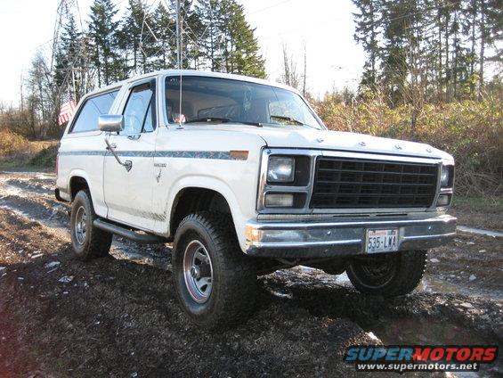 1980 Ford Bronco parked on a muddy trail with trees in the background. License plate reads 535-LWA