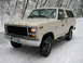 1980 Ford Bronco - A white 1980 Ford Bronco navigates a snowy road, its off-road capability.