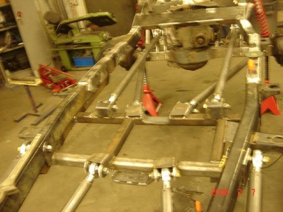 Custom vehicle frame with suspension linkages and red jack stands