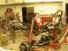 1991 Ford Bronco - A red Jeep Wrangler front end and chassis are disassembled in a workshop, with the year 2006 visible on a floor jack.