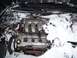 1996 Ford Probe - The engine compartment is heavily covered in snow, obscuring most of the engine details.