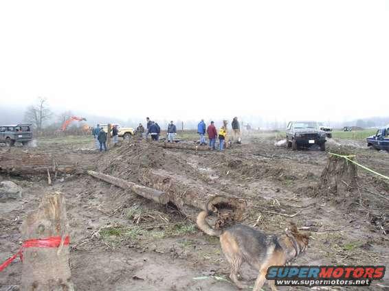 1978 Ford Bronco in mud, front view, with people and other vehicles